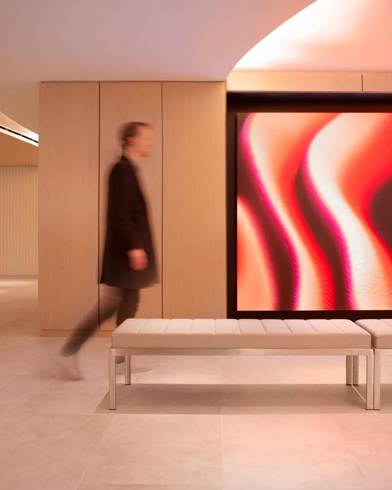 Man walking in front of display with generative visuals